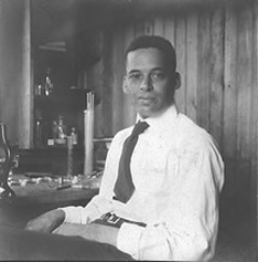 Ernest Everett Just seated at a laboratory bench